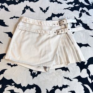 White pleated skirt with shorts / skort with Buckles on side. Size Small.